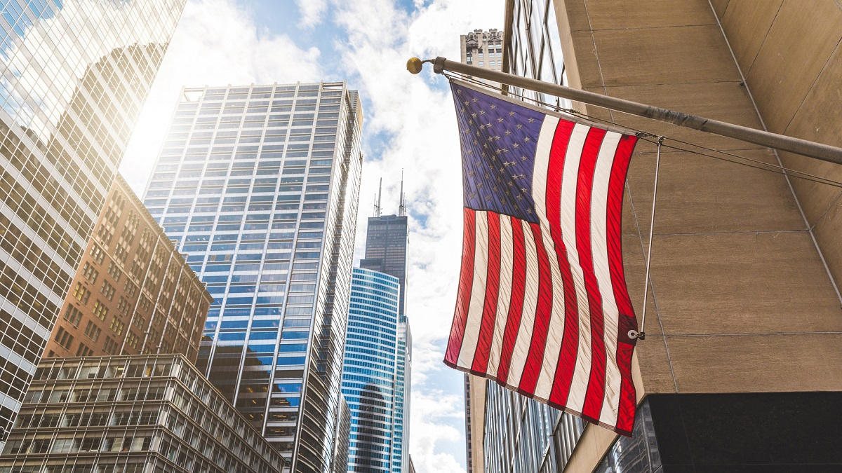 Close up of an American flag with a cityscape background.