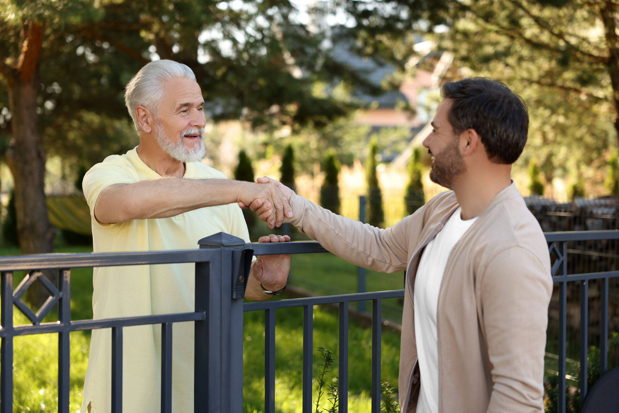 Neighbors talking over their shared fence.