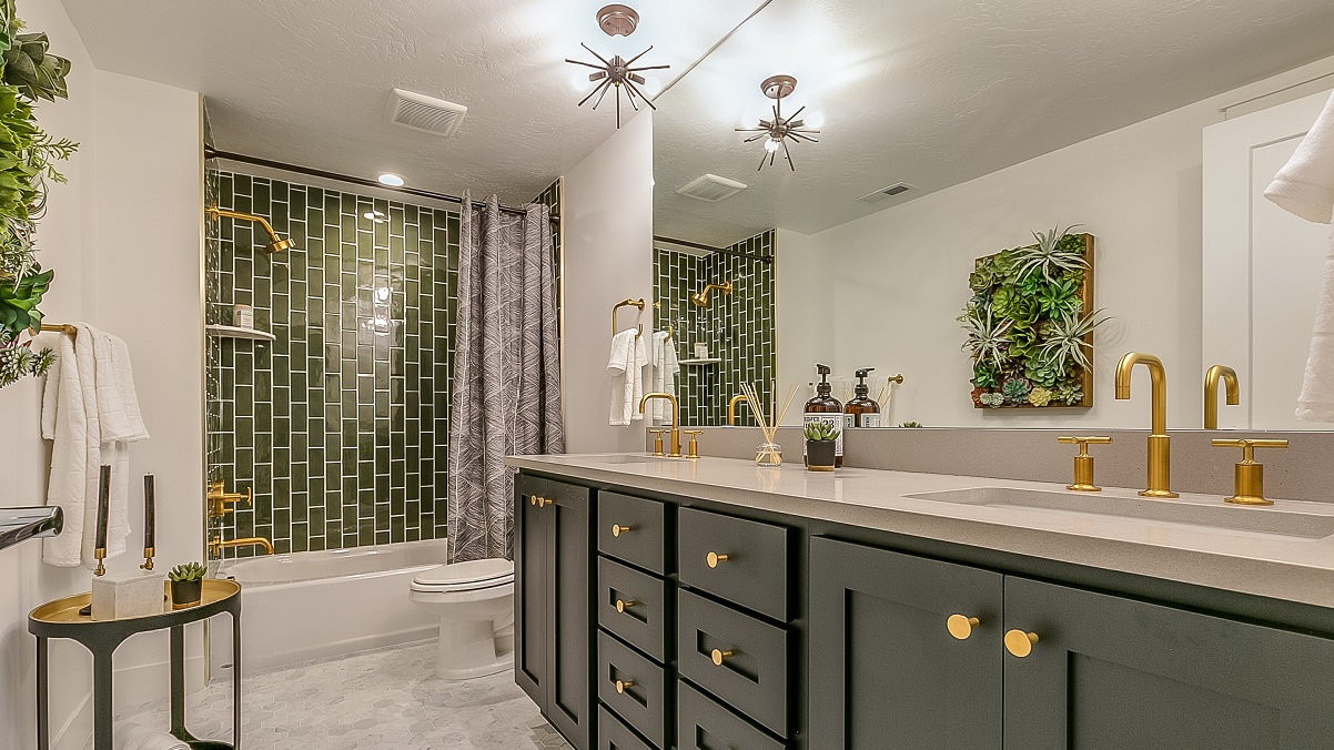 A very nice master bathroom with green and gold accents.